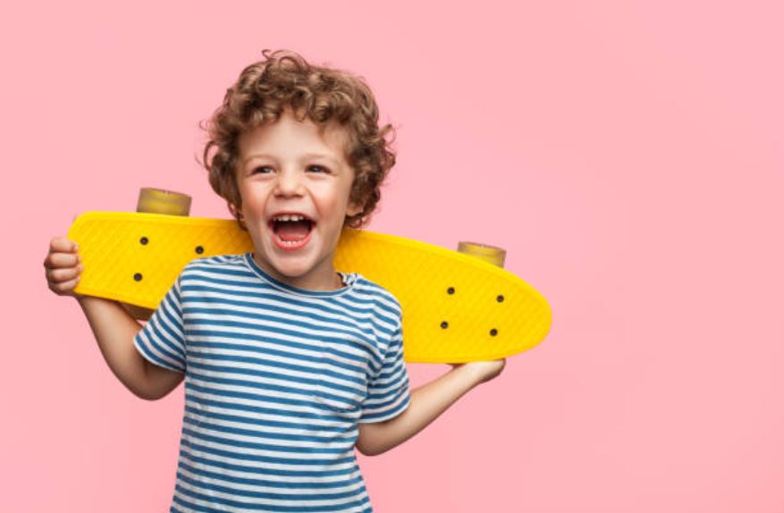 enfant content heureux garçon longboard skateboard